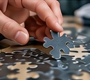 Hand placing a puzzle piece